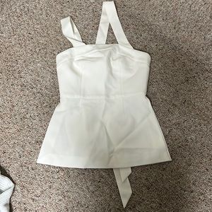 White tank top with asymmetrical straps and open slit sides.